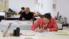 <b>温潜鳞正指导工人对一批新年画进行最后修饰</b>